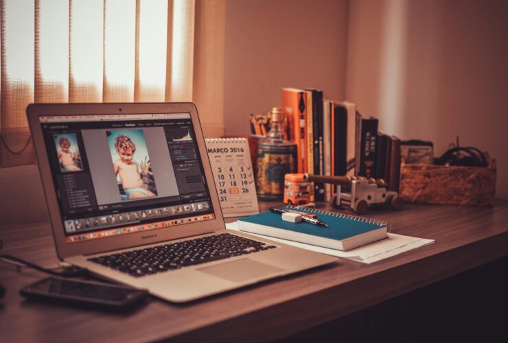 turned on screen silver macbook air on wooden desk